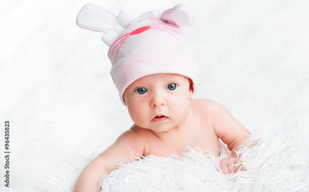 可爱的新生女婴戴着粉色的带耳朵的帽子