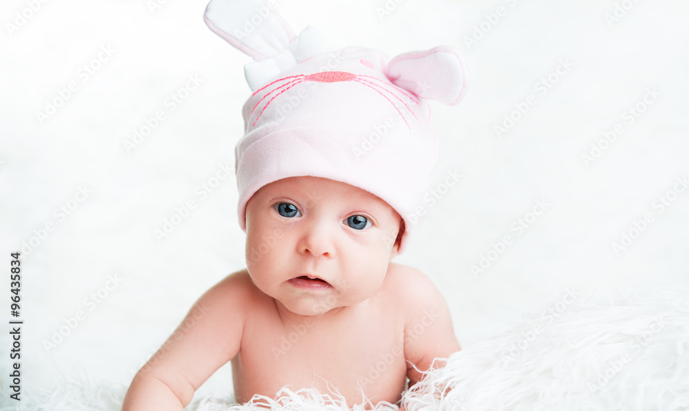 可爱的新生女婴戴着带耳朵的粉色帽子