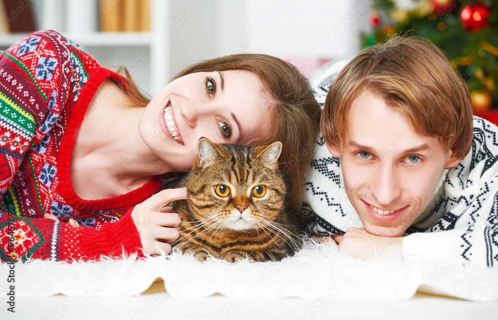 幸福的一对家庭情侣和一只猫在家过圣诞节