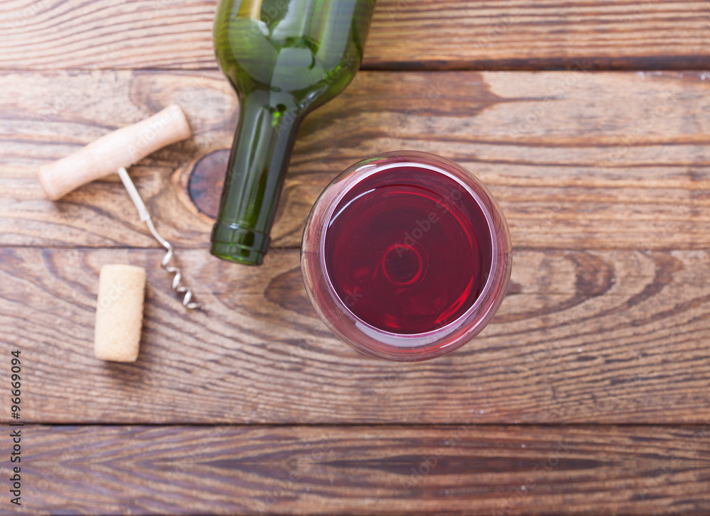 玻璃和一瓶红葡萄酒在木制背景上不同寻常。