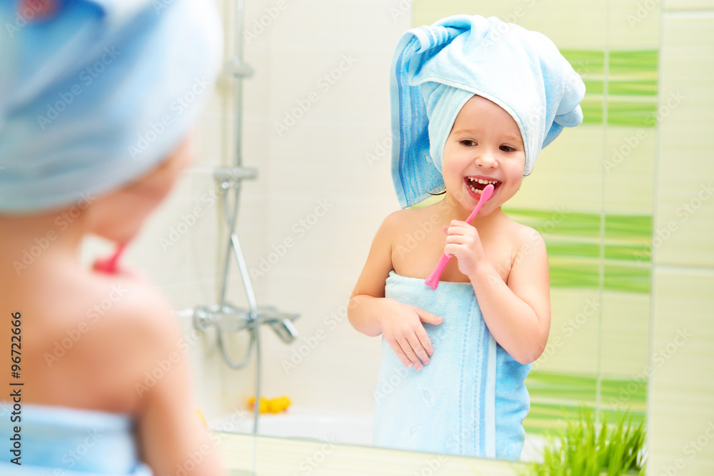 有趣的小女孩在浴室用牙刷刷牙