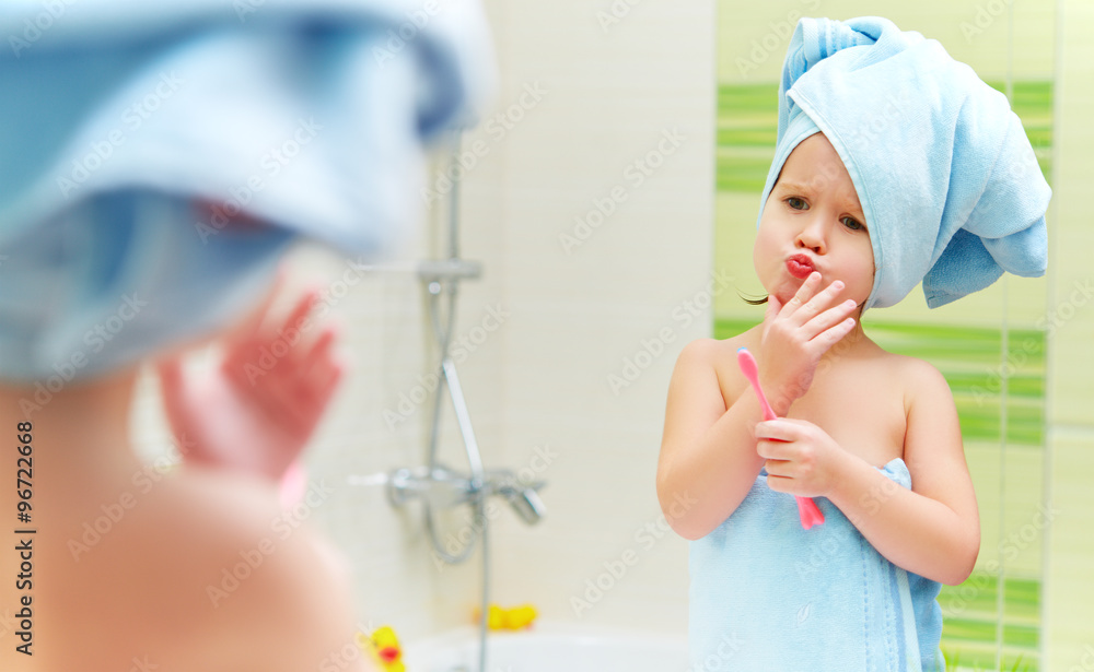 有趣的小女孩在浴室用牙刷刷牙