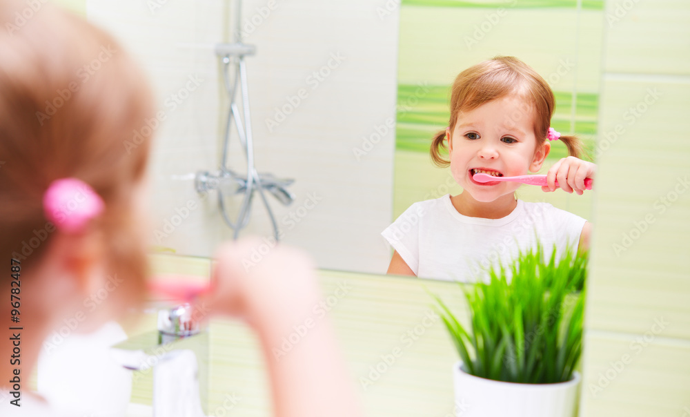 快乐的小女孩在浴室刷牙刷