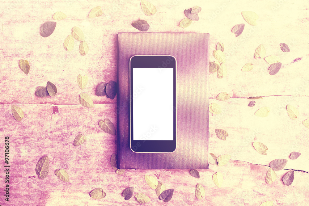 Blank white smartphone screen on diary with diar and leaves on w