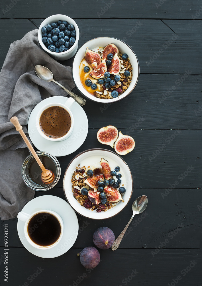 健康早餐套装。一碗燕麦格兰诺拉麦片配酸奶、新鲜蓝莓和无花果、咖啡、蜂蜜。