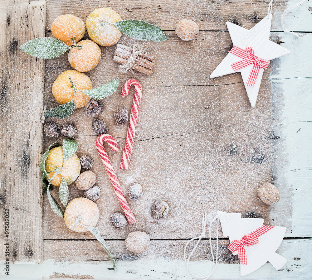 圣诞或新年框架。新鲜的柑橘、肉桂棒、核桃、烤栗子和糖果