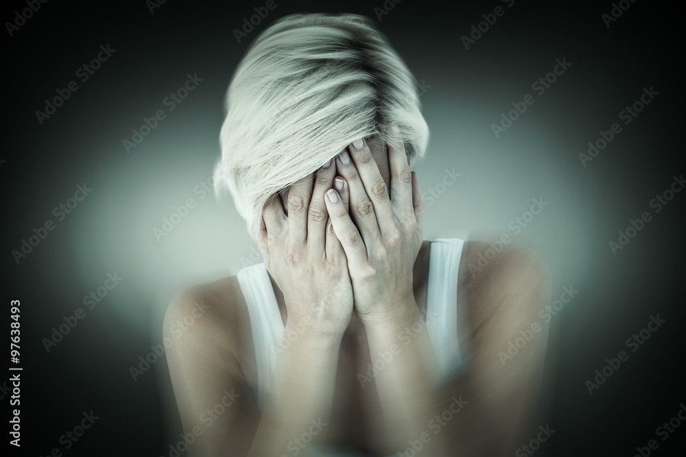 Composite image of sad blonde woman crying with head on hands 