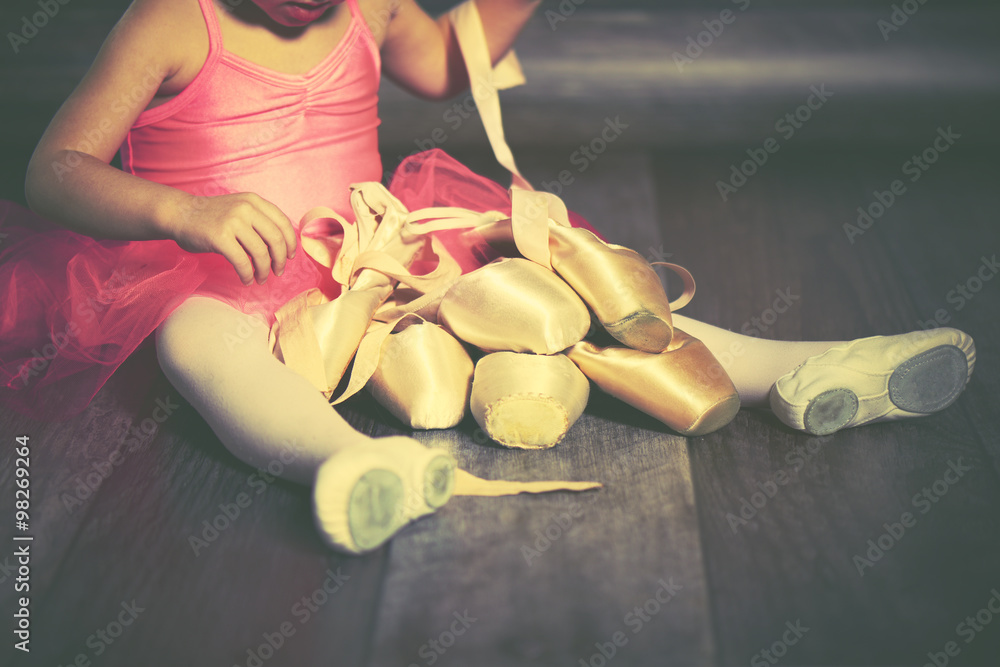穿着芭蕾尖头鞋和粉色裙子的小芭蕾舞演员的腿