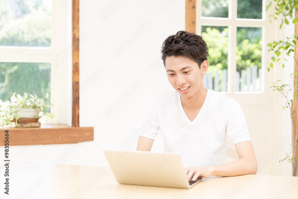 young asian man using laptop