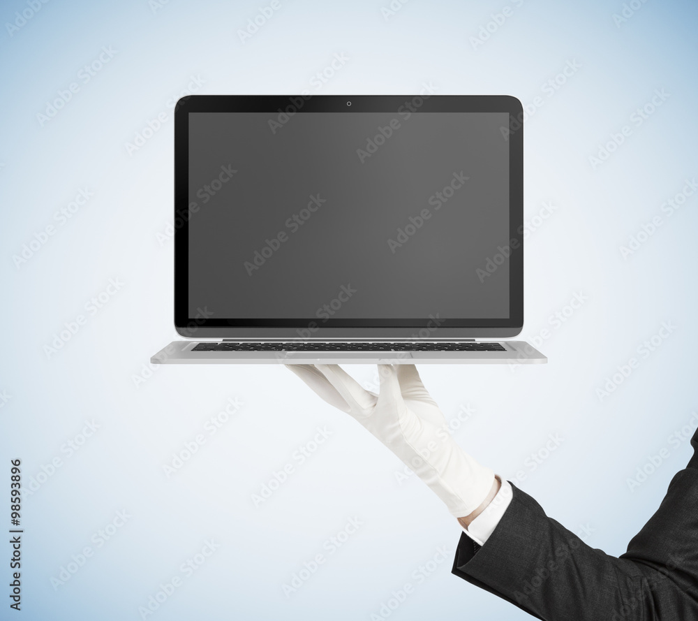 一名男子戴着白色手套，托盘上放着黑色空白笔记本电脑