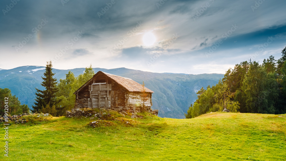 挪威山丘背景下的废弃旧木屋