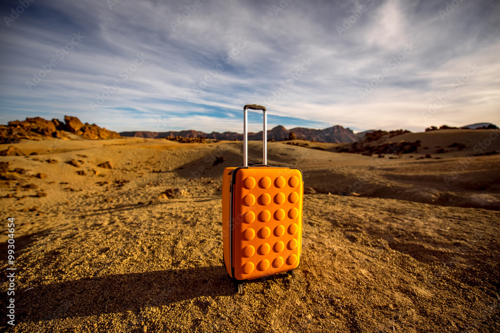 岩石沙漠上的黄色行李箱