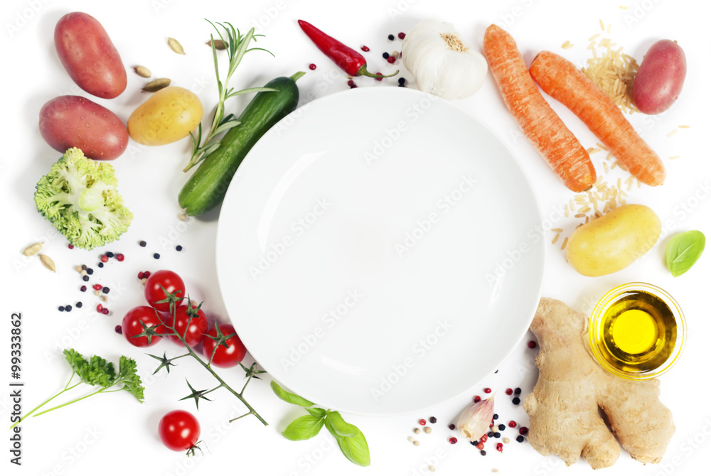 Vegetables around empty white plate