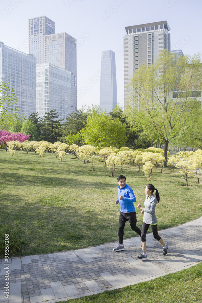 Happy mature couple running in park
