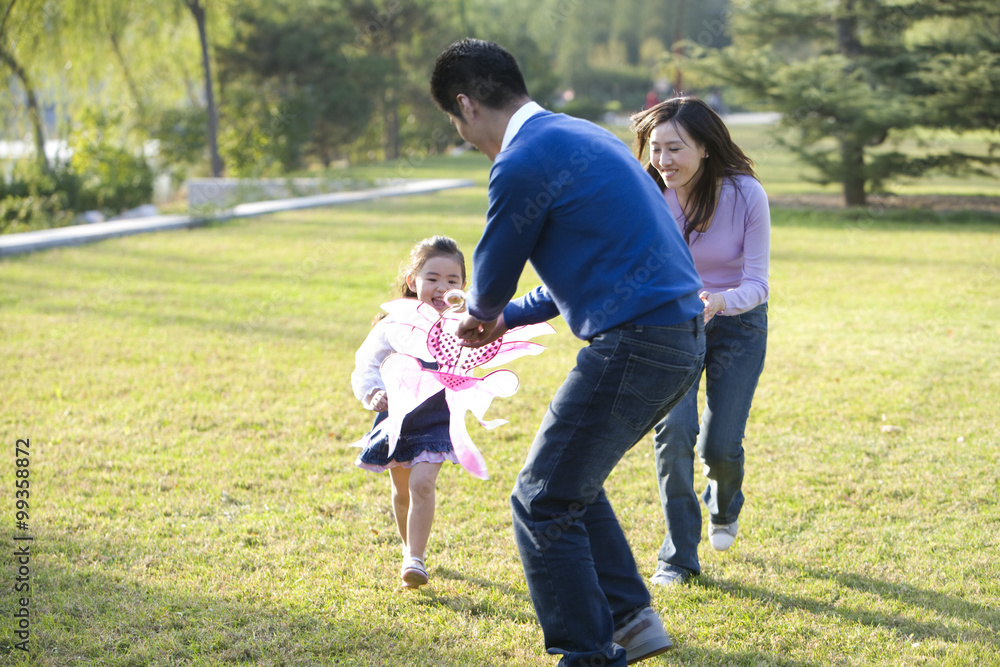 Young family flying a kite in the park