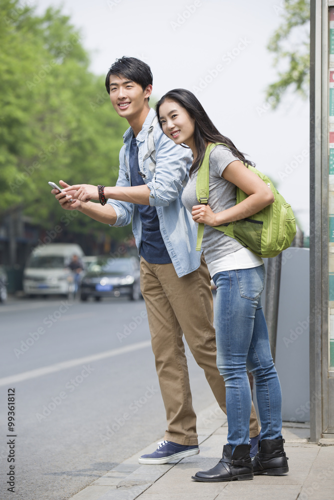 年轻夫妇在公交车站等车