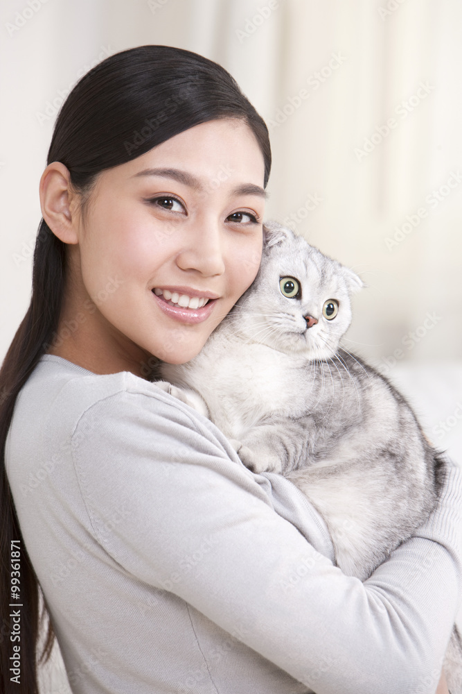 Young woman playing with a Scottish Fold cat
