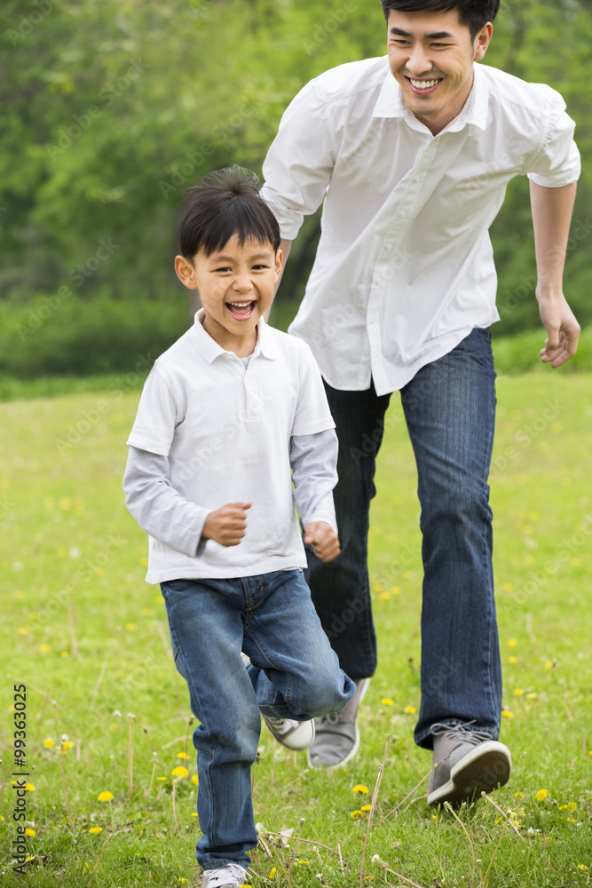Happy father and son running on the grass