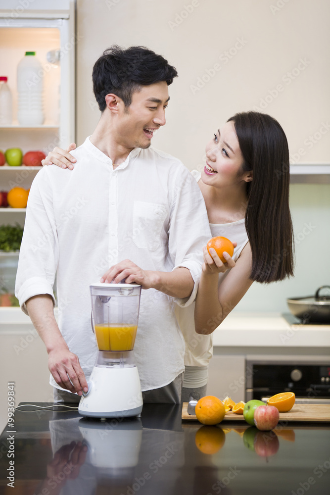 年轻夫妇在厨房使用榨汁机