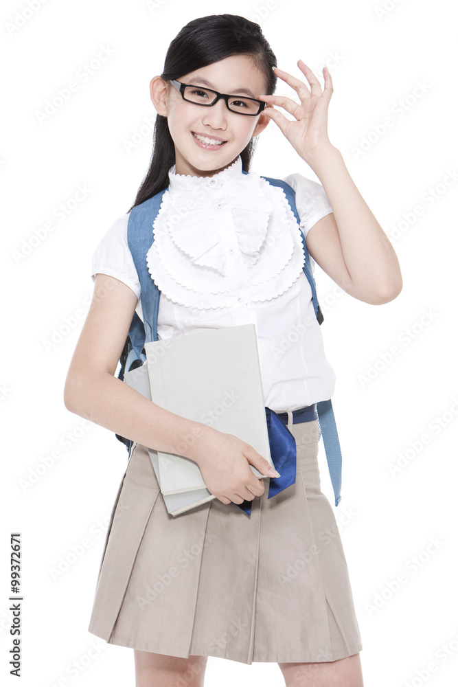漂亮的女学生拿着书和书包调整眼镜