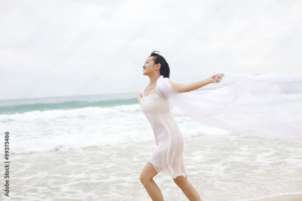 一位年轻女子在海滩上奔跑的肖像