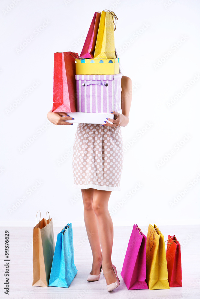 漂亮的年轻女人，带着白色隔离的购物袋和购物箱