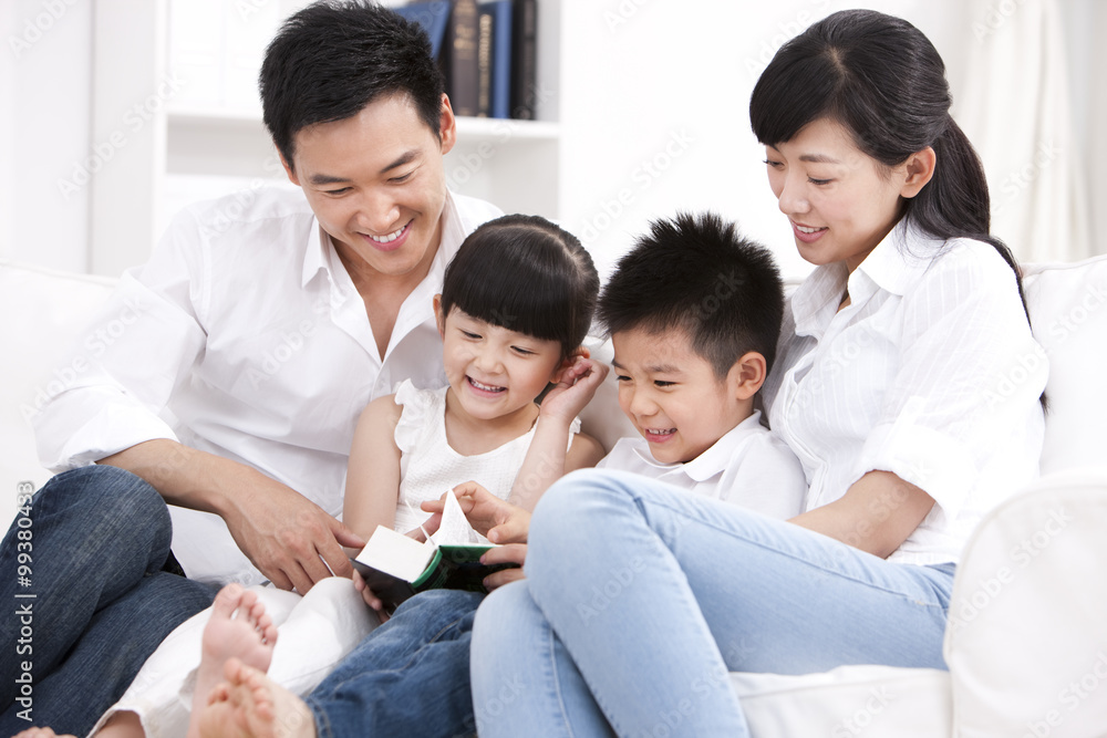 Happy family reading book in sofa