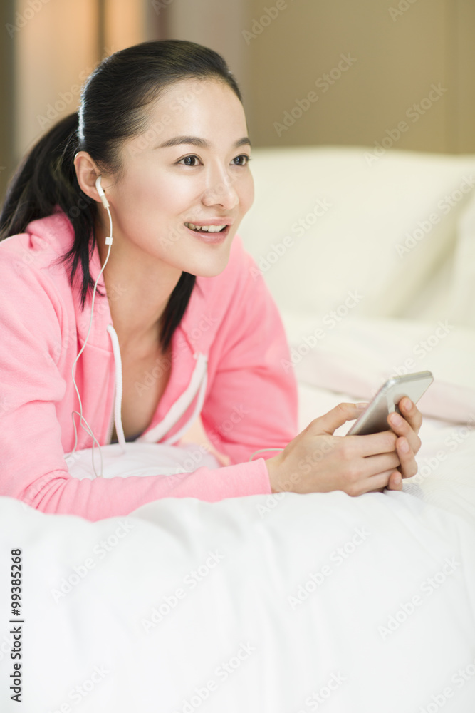 年轻女子在卧室听音乐