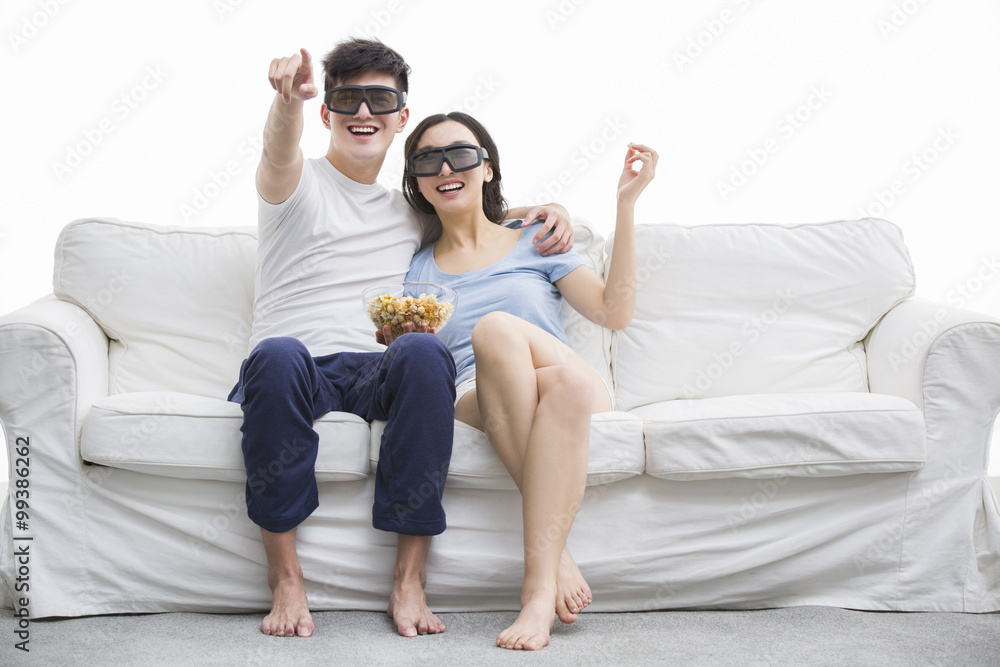 年轻夫妇在客厅看3D电影
