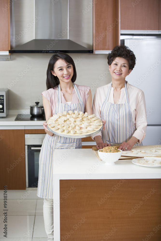 Happy mother and daughter making dumplings