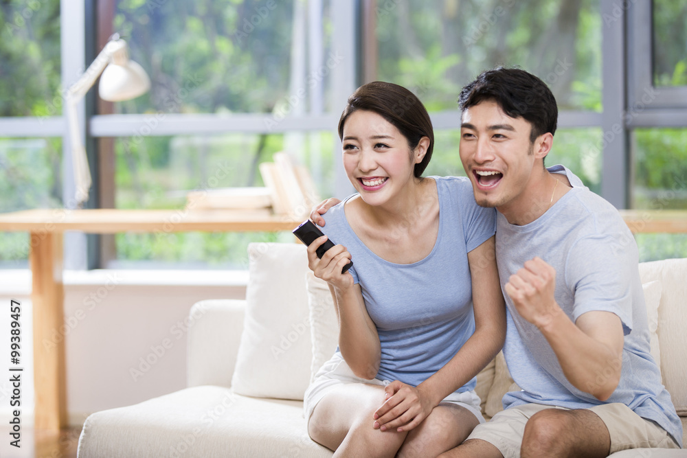 Excited young couple watching TV