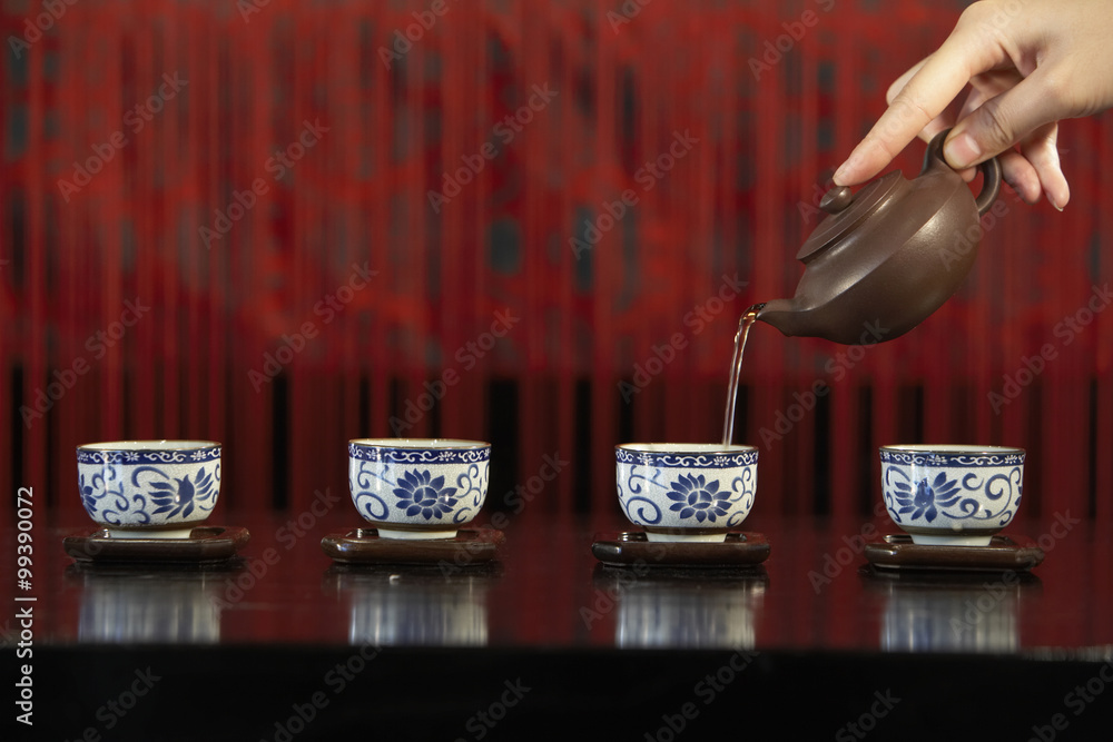 Pouring Tea Into Four Cups