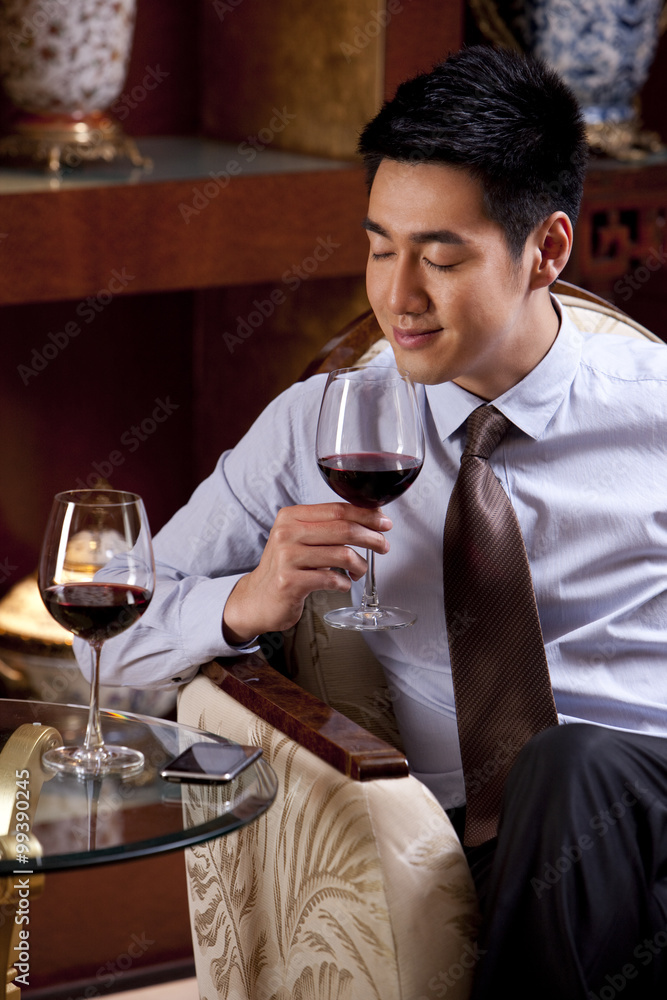 年轻商人在酒店享受葡萄酒
