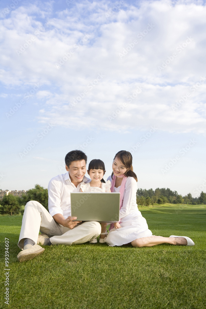 一个年轻的家庭在户外使用笔记本电脑
