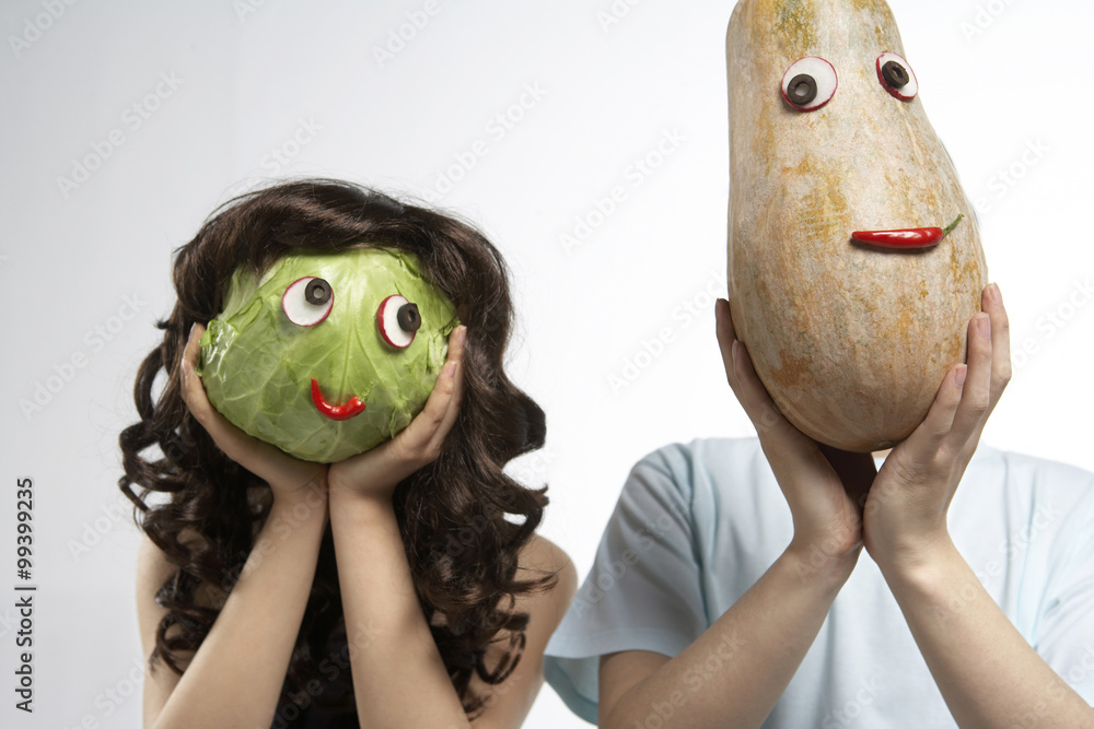 两个人用蔬菜做的口罩遮住脸