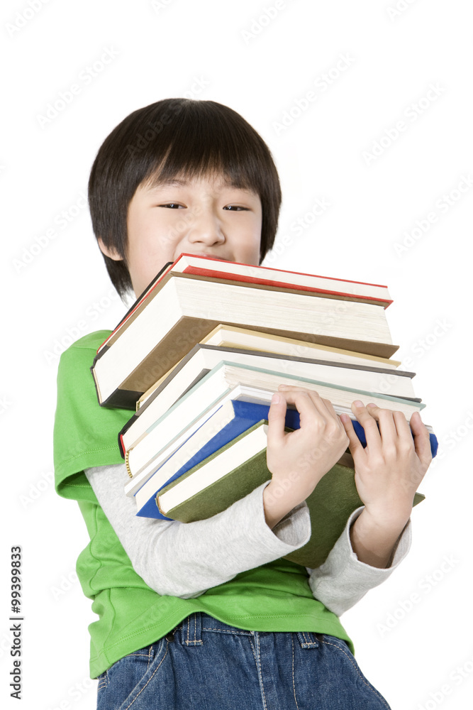 Young boy carrying a large stack of books