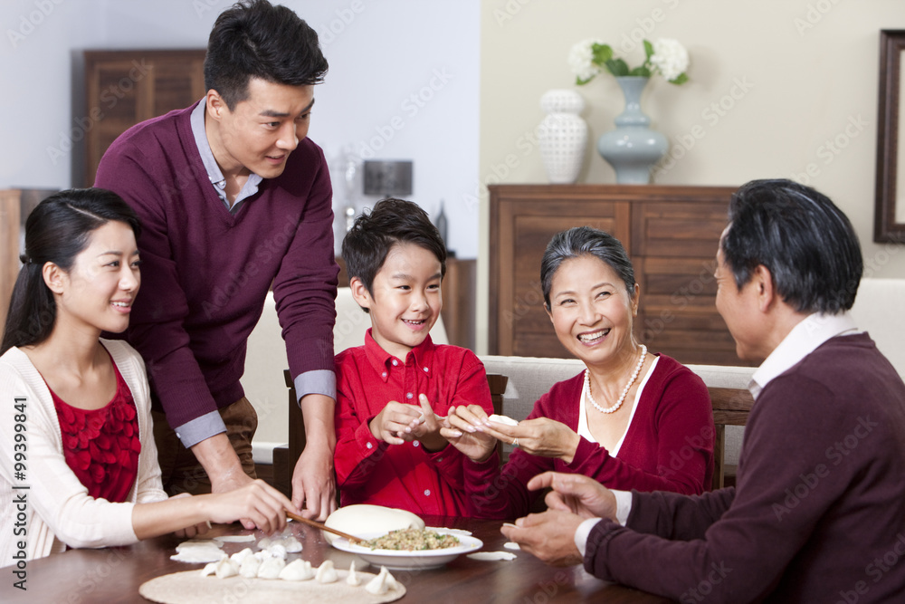 Cheerful family making Chinese dumplings during Chinese New Year