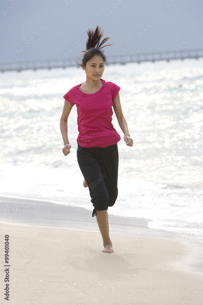 在海滩上跑步的年轻女人