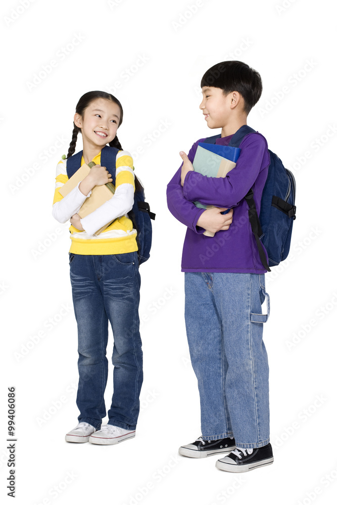 Two students standing and holding their books