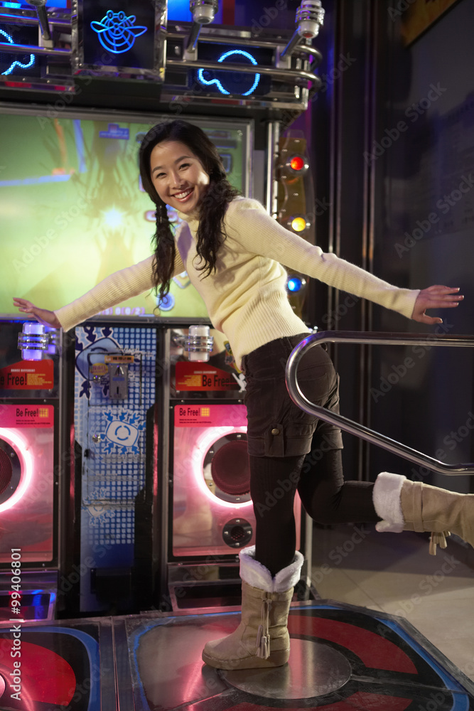 Teenage Girl On Dancing Game At Arcade