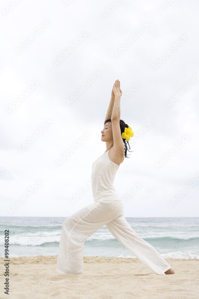 一个女人在海滩上练习瑜伽