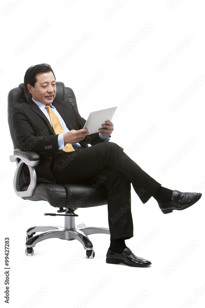 资深商人在董事会椅子上使用数字平板电脑
