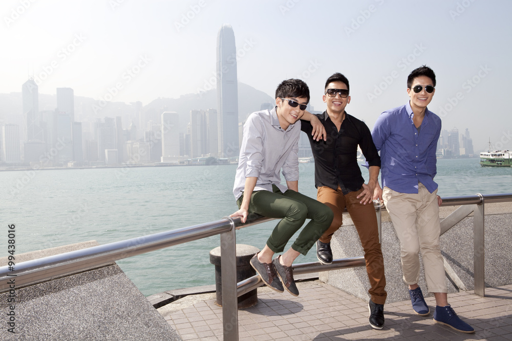 Fashionable young men enjoying the beautiful moment in Victoria Harbor, Hong Kong