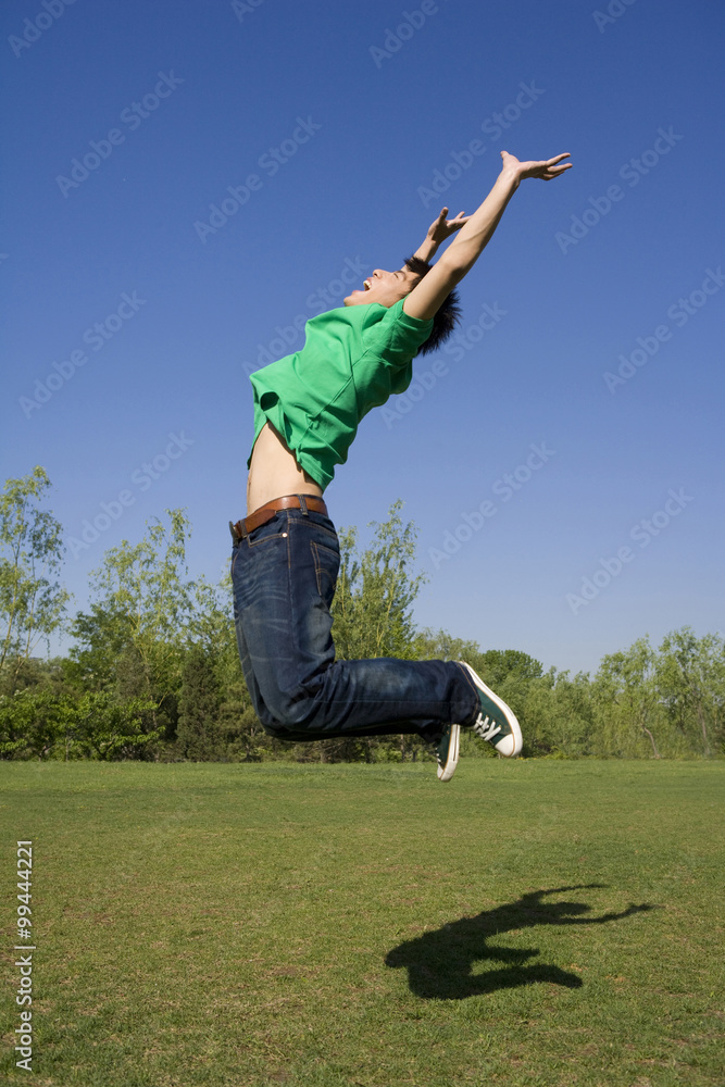 公园里一个年轻人在空中跳跃