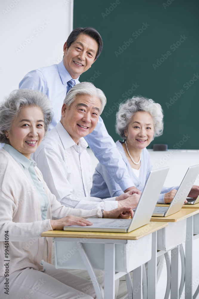 在学校上电脑课的老年人