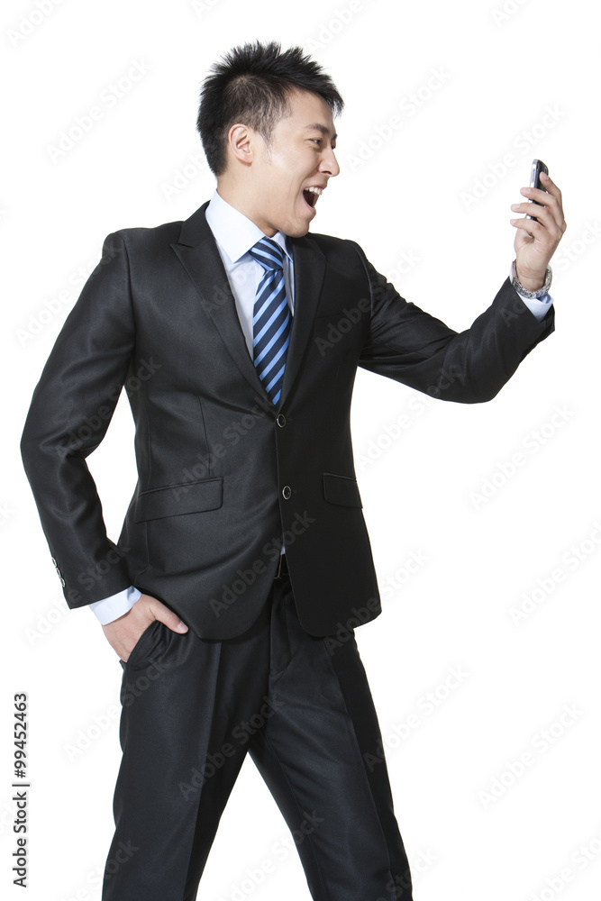一个激动的年轻商人拿着一部手机