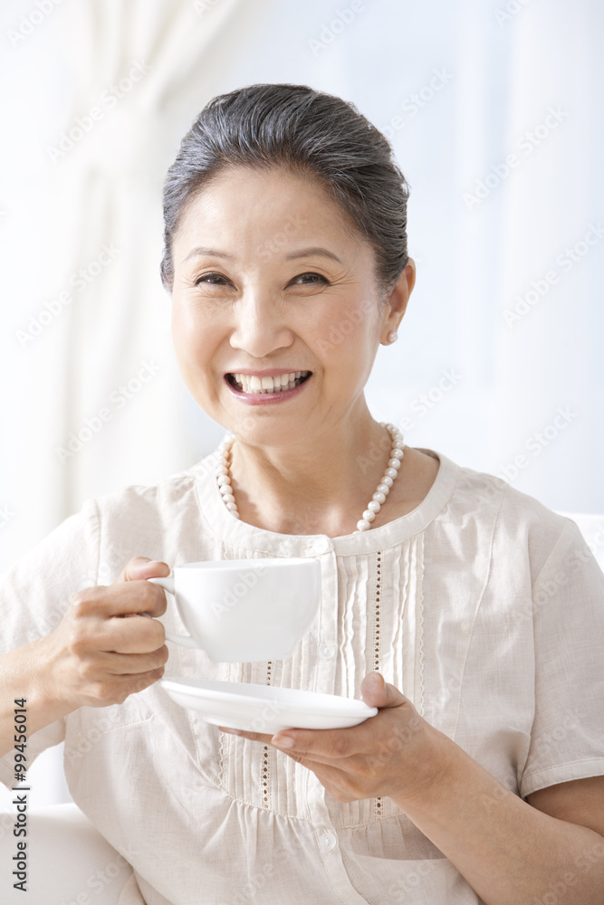 Happy mature woman drinking tea