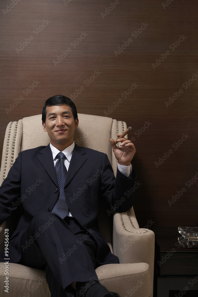 Successful businessman enjoys a cigar