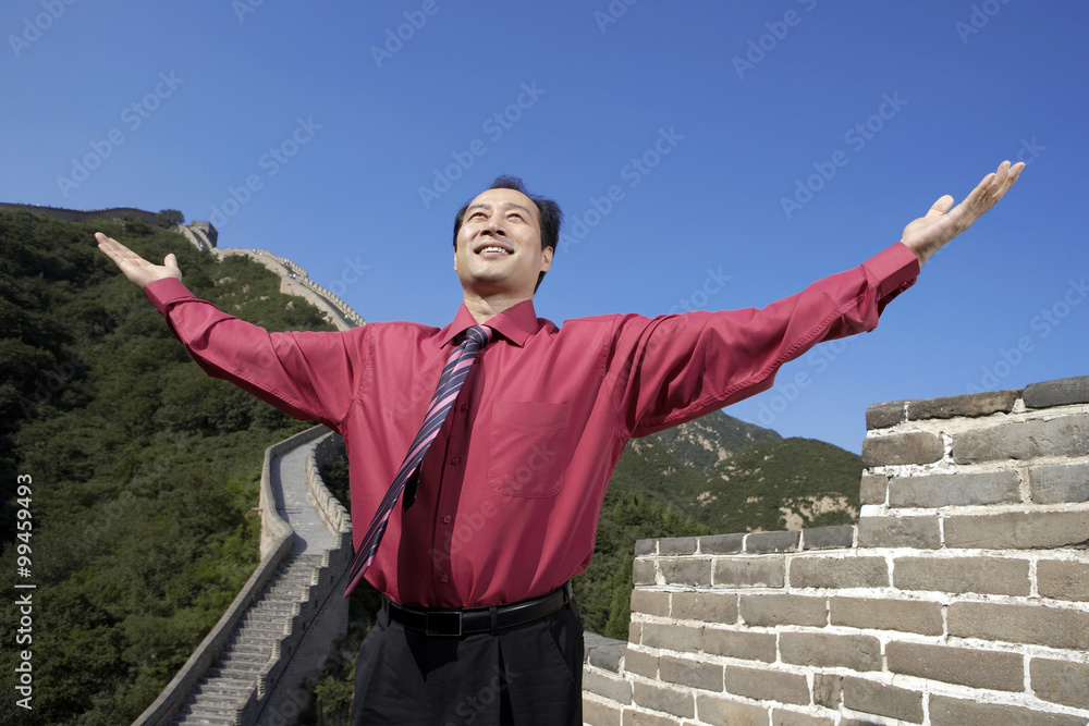 Businessman Standing On The Great Wall Of China, Arms Raised