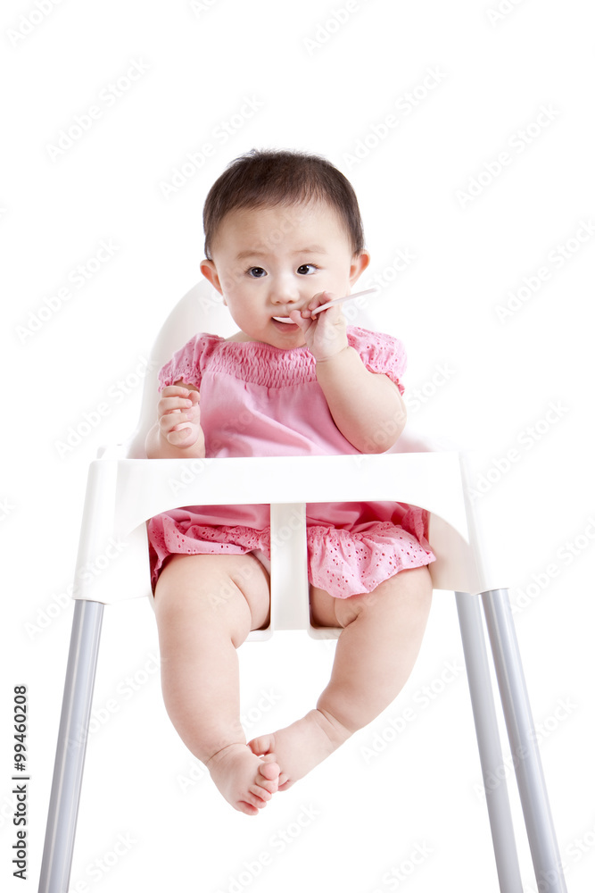 坐在婴儿高脚椅上的可爱女婴
